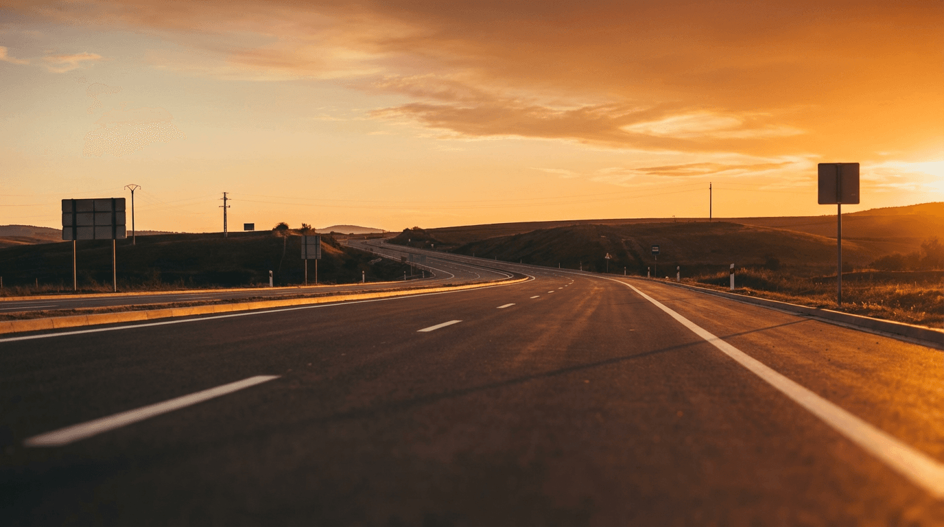 Open highway stretching into rural horizon under blue sky with scattered clouds